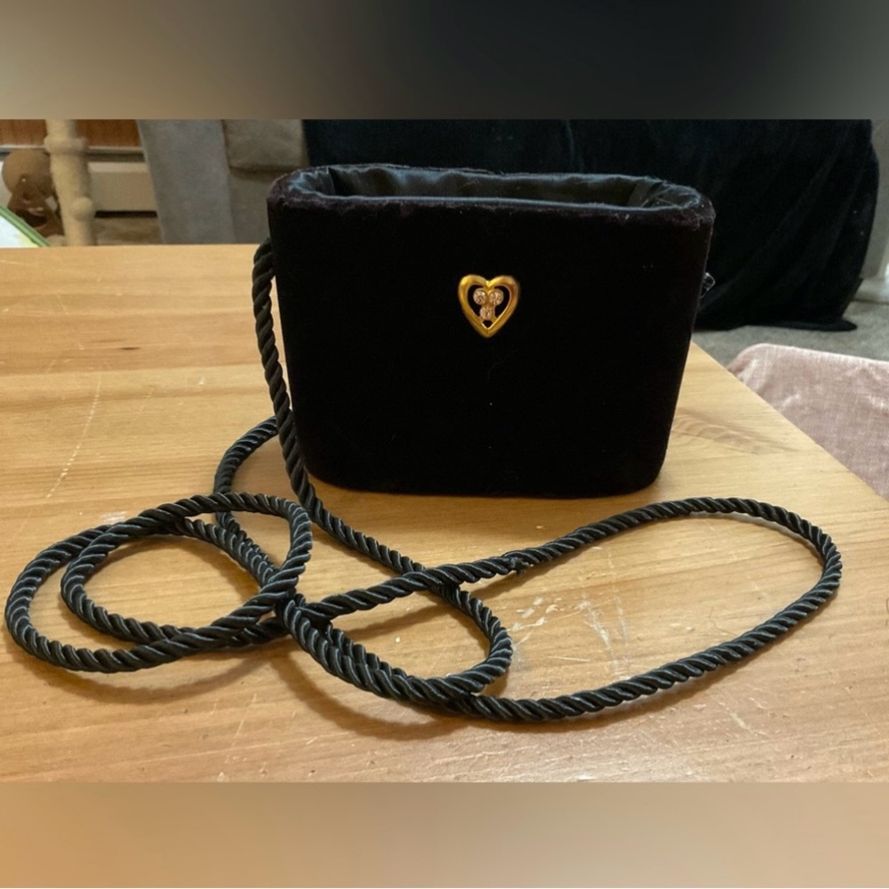 Black small bucket drawstring bag soft about/approximately 3” w/ heart in front.